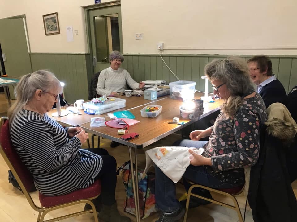 Patchwork Friends working on sewing projects around a table